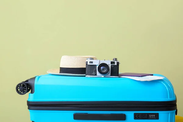 Maleta, sombrero y cámara fotográfica embalados sobre fondo de color. Concepto de viaje — Foto de Stock
