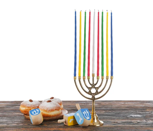 Menorah, donuts for Hanukkah and dreidels on table against white background — Stock Photo, Image