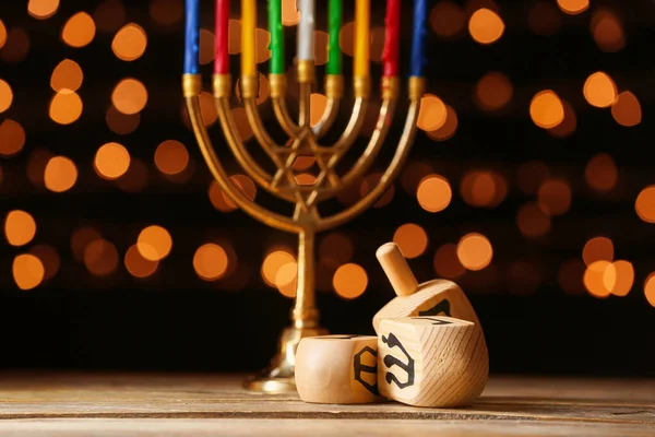 Menorah och dreidels för Hanukkah på bordet mot mörk bakgrund — Stockfoto