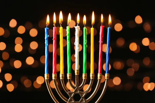 Menorah met brandende kaarsen voor Chanoeka op donkere achtergrond met onscherpe lichten — Stockfoto