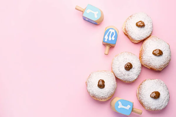 Donuts und Dreidels für Chanukka auf farbigem Hintergrund — Stockfoto