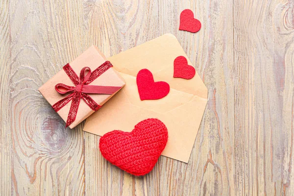 Дар-скринька на День Святого Валентина, конверт і червоні серця на дерев'яному тлі — стокове фото