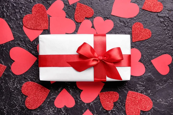 Gift box for Valentine's Day and red hearts on dark background — Stock Photo, Image