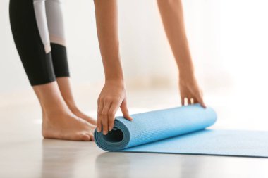 Genç kadın Rolling yoga mat at ev