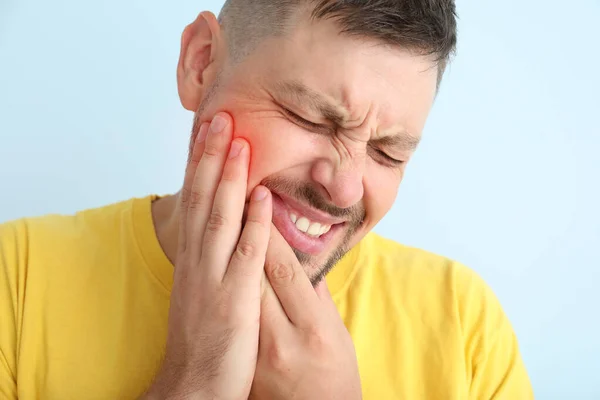 Uomo che soffre di mal di denti su sfondo di colore — Foto Stock