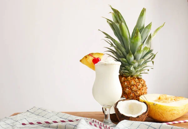 Copo de saboroso coquetel Pina Colada e frutas na mesa — Fotografia de Stock