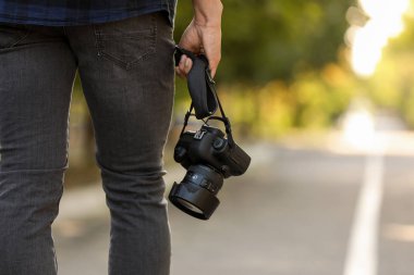 Dışarıda kameralı yakışıklı bir erkek fotoğrafçı, yakın çekim.