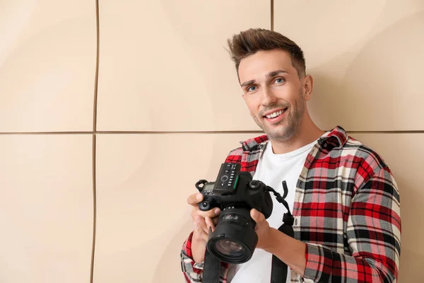 Handsome male photographer near light wall — Stock Photo, Image