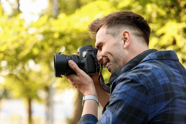 Pohledný mužský fotograf s kamerou venku — Stock fotografie