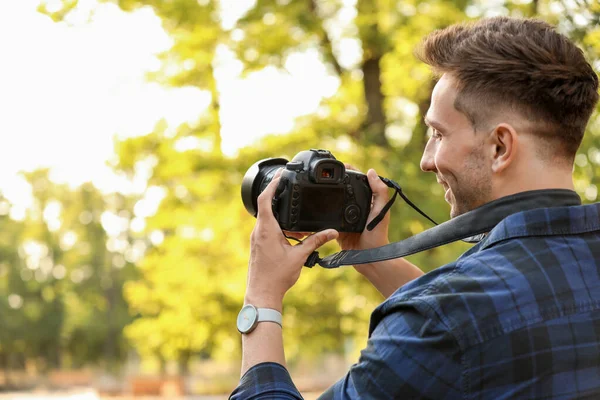 Pohledný mužský fotograf s kamerou venku — Stock fotografie