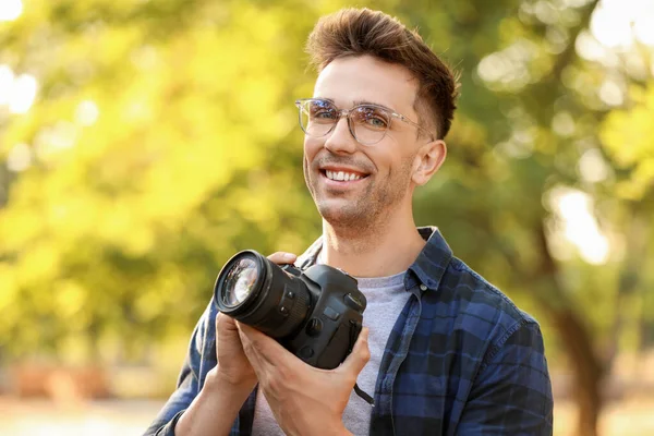 Knappe mannelijke fotograaf met camera buitenshuis — Stockfoto