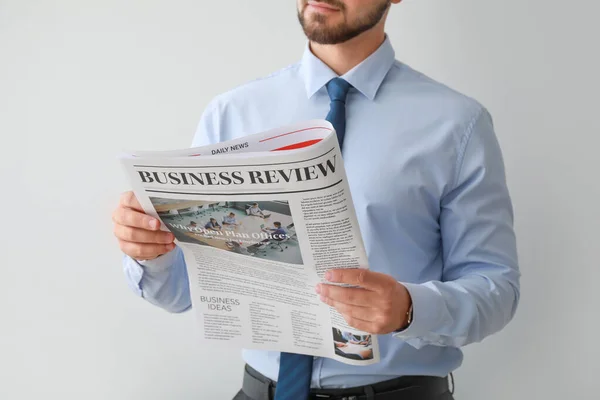 Hombre de negocios guapo con periódico sobre fondo claro — Foto de Stock