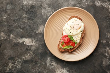 Koyu arkaplanda lezzetli bir sandviç tabağı.