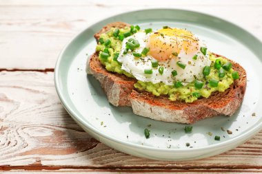 Beyaz ahşap arka planda lezzetli bir sandviç tabağı.