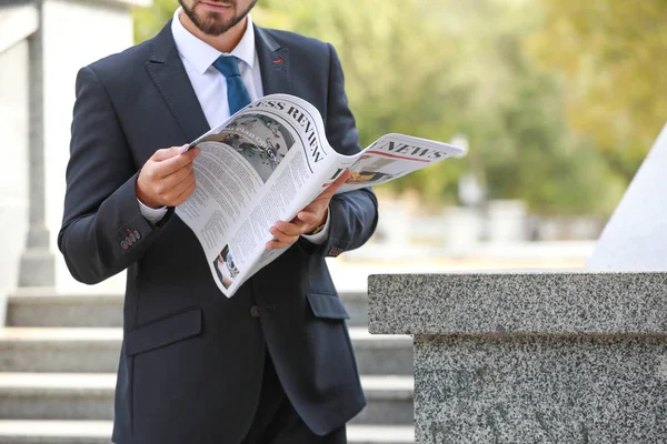 Hombre de negocios guapo con periódico al aire libre — Foto de Stock