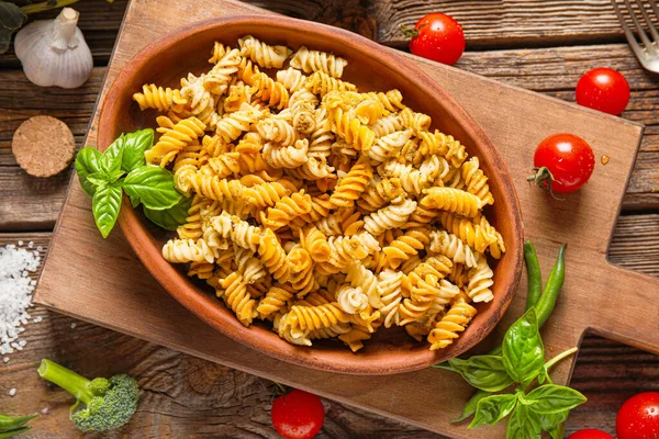Plate with tasty pasta and pesto sauce on wooden table — Stock Photo, Image