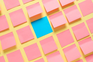 Pembe olanlar arasında mavi kağıt kaplama, arka planda. Eşsizlik kavramı