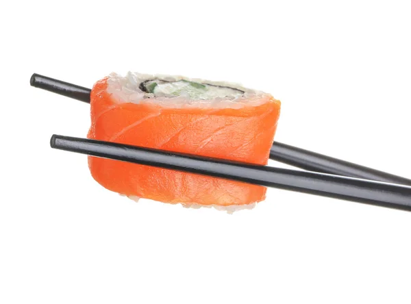 Palillos con sabroso rollo de sushi sobre fondo blanco —  Fotos de Stock