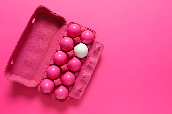 White egg among pink ones in package. Concept of uniqueness — Stock Photo, Image