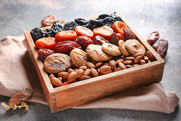 Box with different dried fruits and nuts on grey background — Stock Photo, Image