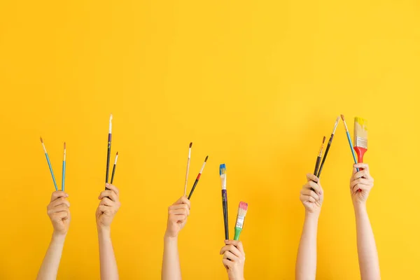 Female hands with painter's supplies on color background — Stock Photo, Image