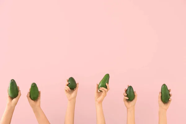 Renkli arka planda taze avokadoları olan kadın elleri — Stok fotoğraf