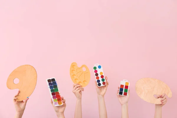 Mãos femininas com suprimentos de pintor no fundo de cor — Fotografia de Stock