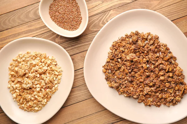 Plates with tasty granola on wooden background — Stock Photo, Image