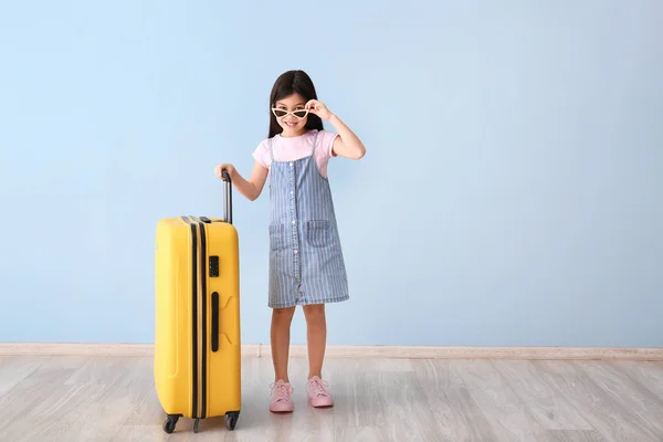 Cute girl with suitcase near color wall — Stock Photo, Image