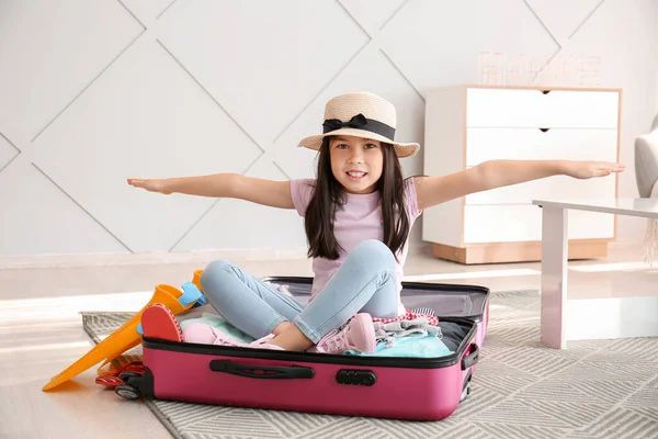 Chica feliz con maleta y pertenencias en casa — Foto de Stock