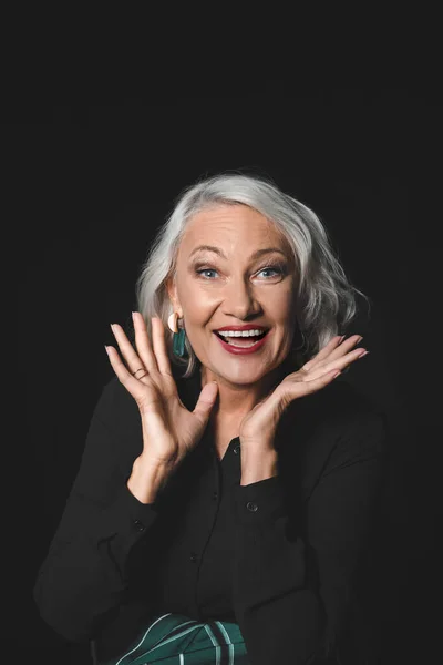 Portrait of stylish excited mature woman on dark background — Stock Photo, Image