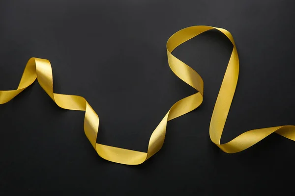 Beautiful golden ribbon on dark background — Stock Photo, Image