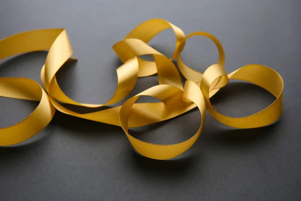 Beautiful golden ribbon on dark background — Stock Photo, Image