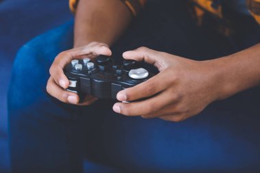 Afro-Amerikalı genç çocuk evde video oyunu oynuyor, yakın plan.