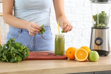 Kadın evde sağlıklı meyve püresi yapıyor.