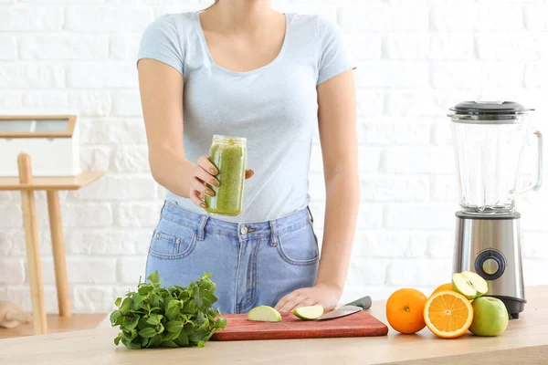 Vrouw met gezonde zelfgemaakte smoothie in keuken — Stockfoto