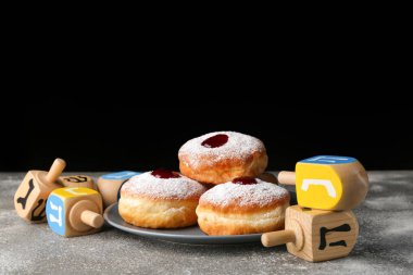 Hanukkah ve Dreidels için donutlar koyu arkaplanda