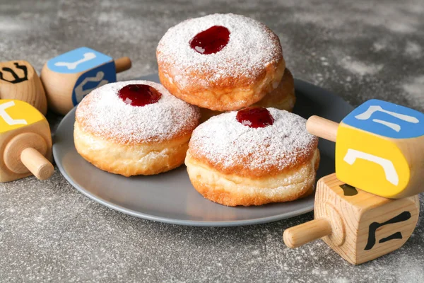 Donuts for Hanukkah and dreidels on table — Stock Photo, Image