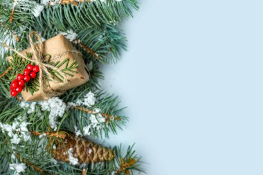 Açık arkaplanda Noel hediyesi olan yeşil köknar dalları