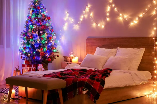 A hálószoba belseje gyönyörű díszített karácsonyfával éjjel — Stock Fotó