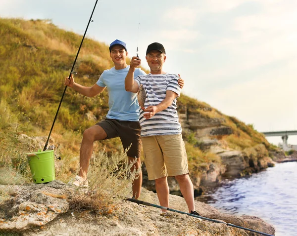 Joven y su padre pescando en el río — Foto de Stock