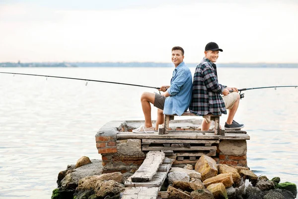 Jongeman en zijn vader vissen op de rivier — Stockfoto