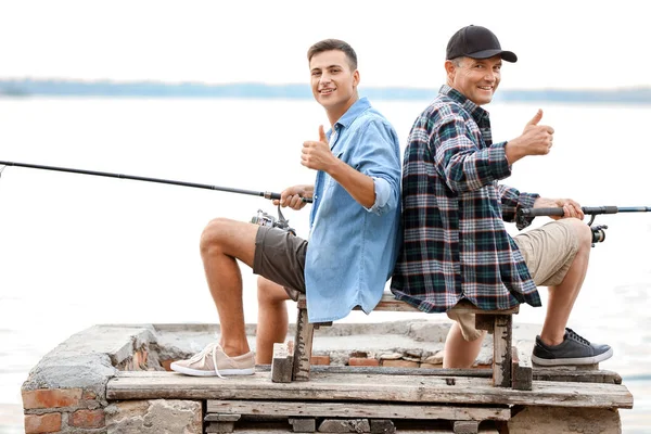 Joven y su padre pescando en el río — Foto de Stock