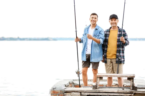 Jovem e seu pai pescando no rio — Fotografia de Stock