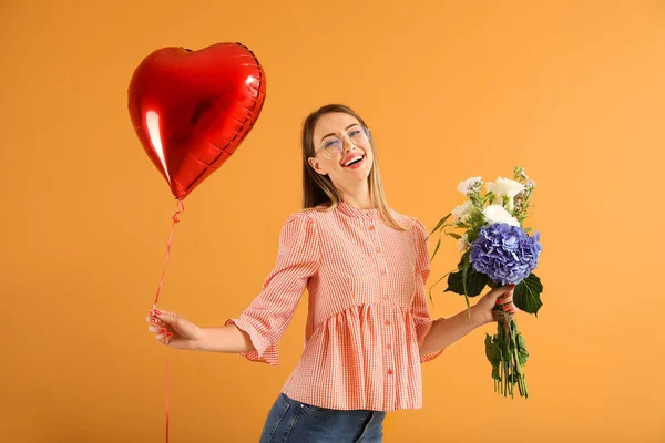 Beautiful young woman with air balloon and flowers on color background — Stock Photo, Image