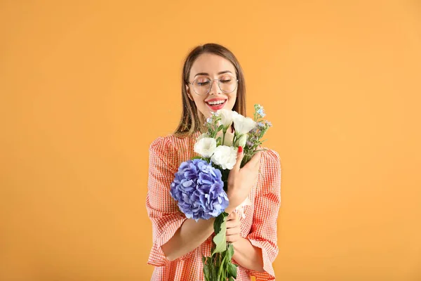 Beautiful young woman with flowers on color background — Stock Photo, Image