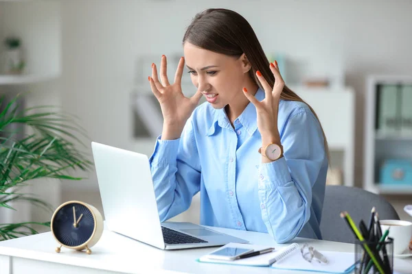 Stressed young woman trying to meet deadline in office — Stock Photo, Image