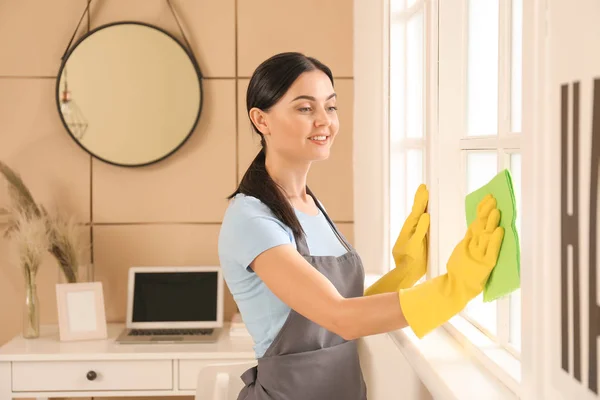 Hausmeister putzt Fenster im Zimmer — Stockfoto