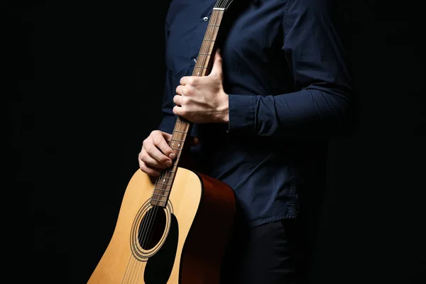 Bello uomo con chitarra su sfondo scuro — Foto Stock