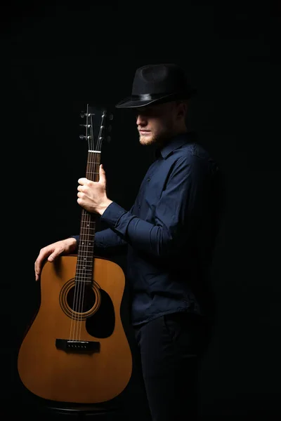 Handsome man with guitar on dark background — Stock Photo, Image